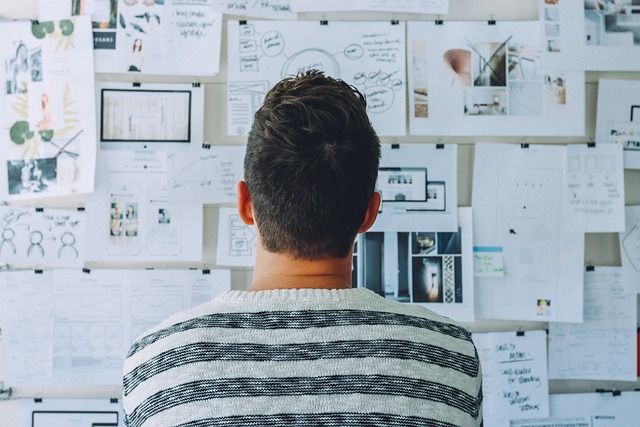 person looking at a wall of work and ideas