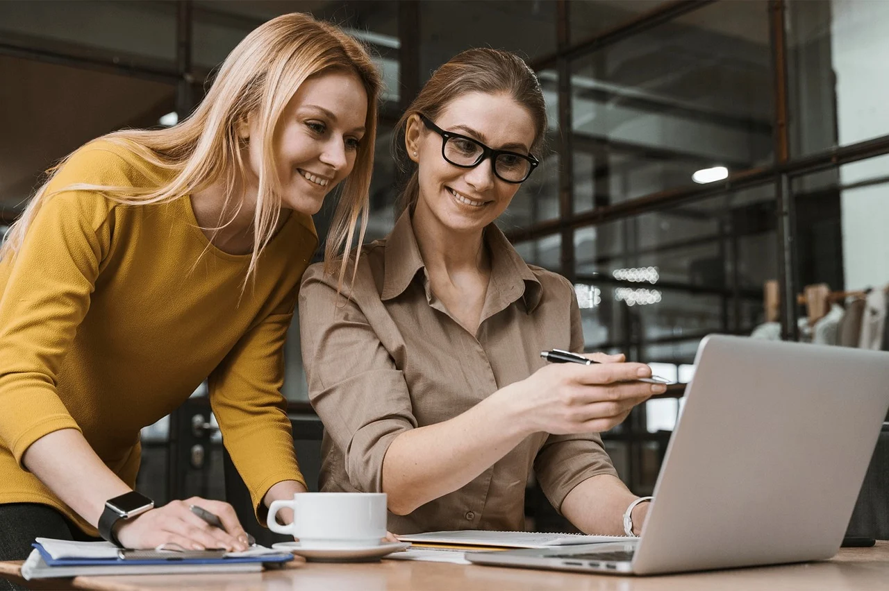 two women working on a laptop